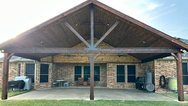 Larged covered patio with a vaulted wooden ceiling.