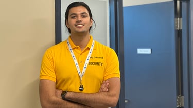 a man in a yellow shirt standing beside a door