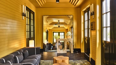 Kelly Wearstler design a hallway with a couch and a table.