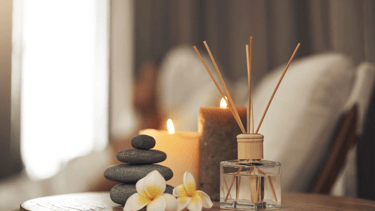 A medspa image of candles, incense, and balanced stones.