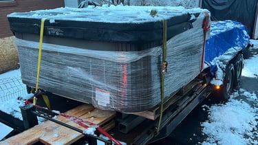 A trailer loaded with a hot tub and lumber for delivery 