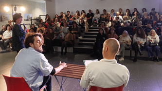 de dos deux hommes assis côte à côte avec public en face forum handicap et emploi