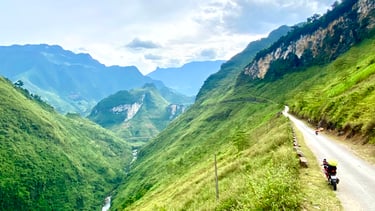a motorcycle rider riding down a mountain side