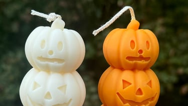 Two pumpkin candles outdoors