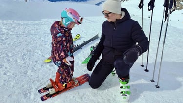 a woman and a child are standing in the snow
