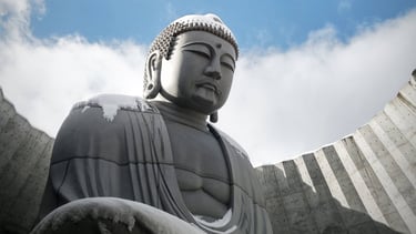 a concrete buddha statue sitting in a circular hole