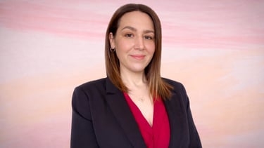 Approachable bookkeeping professional in business attire, smiling confidently against a soft pastel