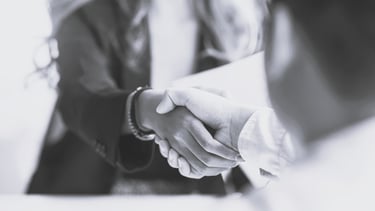 a woman shaking someone's hand over a table