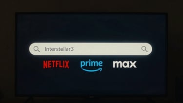 Minimalist user interface mockup of a search bar with the text 'Interstellar' and colorful streaming platform tags for Netflix, Prime, and Max floating underneath, glowing ambient light
