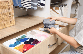 folded clothing sorted into drawer organizer during home organization