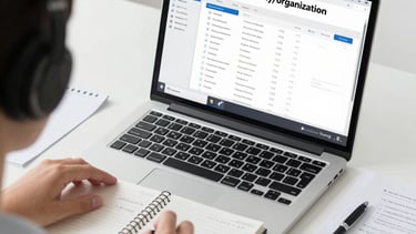 Asian virtual assistant working on a laptop in a clean modern office, professional business environm