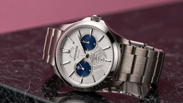 A sophisticated lifestyle shot of a high-end designer watch resting on a reflective black marble surface with soft magenta studio lighting, North American luxury style.