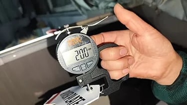 Quality control at ballsvendor.com showing precision thickness measurement of sports ball materials to ensure durability.