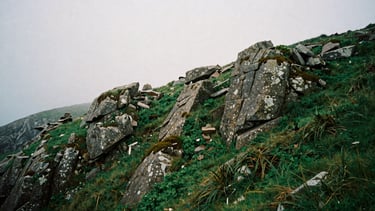 moody coastal photography, soft overcast daylight, deep green and granite tones, misty Galician landscape, 35mm film
