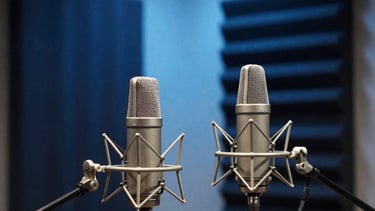 A high-end, minimalist recording studio featuring professional microphones and soundproofing. The room is bathed in sophisticated deep navy blue and sky blue accent lighting. Global / International atmosphere.