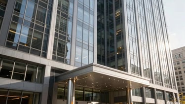 Professional architectural photography of a modern high-rise corporate office building entrance in Chicago, Illinois. The scene features clean glass facades and steel accents under bright morning sunlight, reflecting a reliable and established business image in North American / US style. Colors include deep slate grey and white.