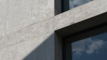A close-up architectural detail of textured concrete and glass. Sophisticated play of shadow and light in midnight blue and cloud white. Modernist design aesthetic.
