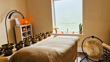 Treatment couch with singing bowls laid on a table, gong and seed chimes