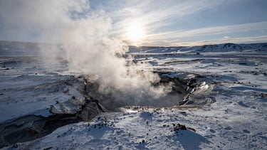 High-contrast wide anamorphic cinematic still of a cold, sub-zero graded volcanic landscape with steam rising from a fissure, dramatic low sun on the horizon.
