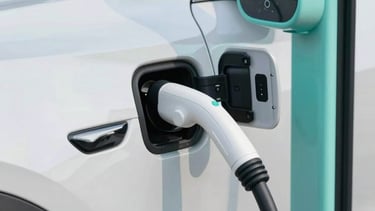 Close-up of a modern electric vehicle charging station with a sleek design, reflecting a pearl white and light aqua color scheme. Professional photography.