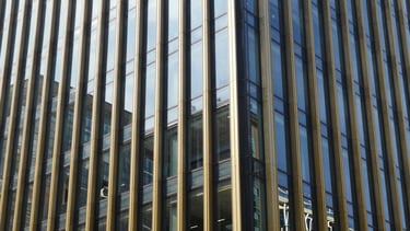 Modern corporate office building facade, geometric glass reflections, bright daylight, editorial style