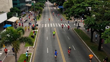 An aerial shot of a corporate marathon in São Paulo, with runners moving through a major avenue. Dynamic motion blur and vibrant colors. South American / Brazilian urban environment.