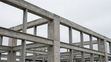 Crisp architectural photography of exposed structural steel framing and raw poured concrete, natural overcast daylight, desaturated slate tones, sharp focus, 35mm