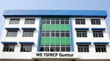 Authentic civic photography of the clean, professional facade of the WE YSRCP Guntur office building, bright natural daylight, no people, clean blue and green accents, sharp focus, 35mm lens