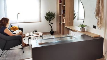 Rincón de lectura con librería a medida y chimenea, IMPATTO interiorismo