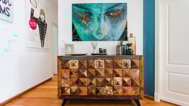 Interiorismo con estilo ecléctico. Mobiliario de madera y gran cuadro, realizado por los mejores interioristas de Valencia