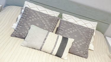 Selección de cojines colores neutros para un dormitorio