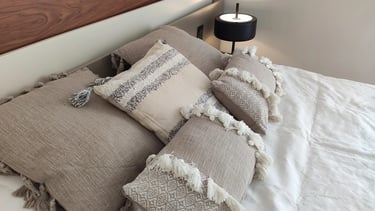 Selección de cojines colores neutros para un dormitorio