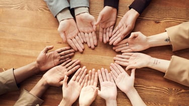 6 people's hands palms up making a circle