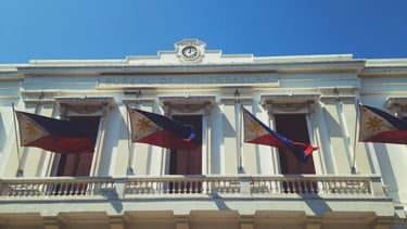 a building with a clock and flags on it