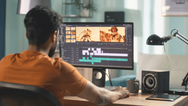 Male video editor focused on editing video content at his workstation