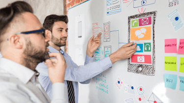 Digital marketing expert and client discussing content strategy in front of a whiteboard