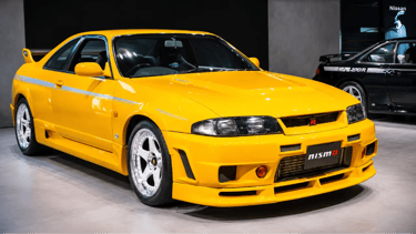 Nissan Skyline GT-R R33 Nismo 400R amarelo em exposição com body kit exclusivo