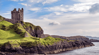 Ancient castle sitting on rocky cliff with water
