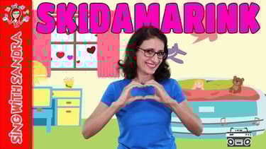 a woman in a blue shirt and glasses making a heart shape