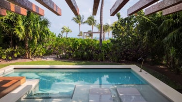 A view of the pool from the Honeymoon Suite at an Excellence Resort, palm trees