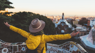 a woman in a yellow jacket and hat with her arms outstretched out