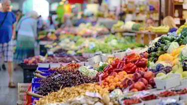 a variety of fruits and vegetables are displayed in a market