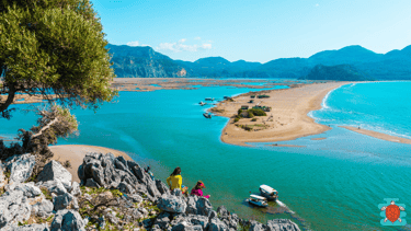 a group of people standing on a cliff overlooking Iztuzu Beach