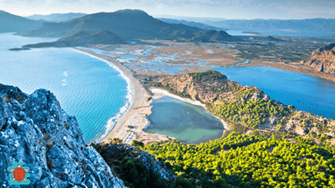 a person standing on a mountain top with a view of Iztuzu Beach