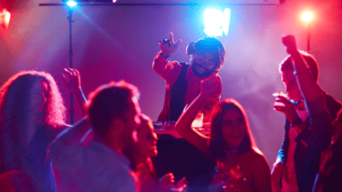 a man in a red jacket is dancing at a party