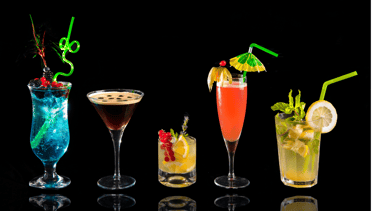 a variety of drinks in a row of glasses