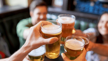 a group of people are toasting with beer