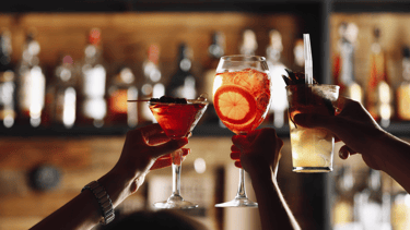 a couple of people holding glasses with drinks