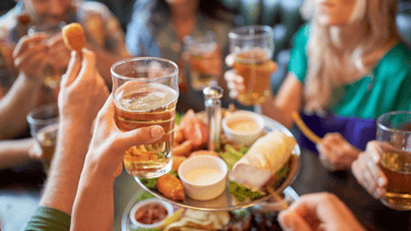 a group of people eating food and drinking
