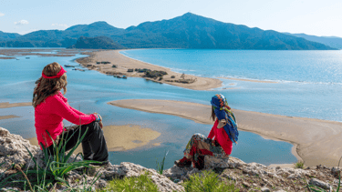 two women sitting on a rock overlooking to Iztuzu Beach